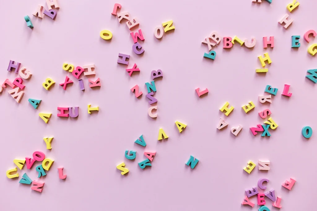 Diversas letras del alfabeto en diferentes colores sobre un fondo morado, simbolizando la formación de palabras intraducibles