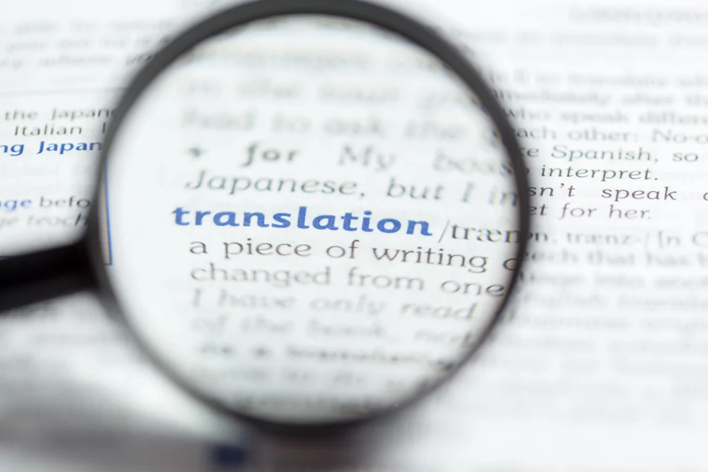 Lupa enfocada en la palabra "translation" en un diccionario, concepto fundamental para la tecnología de traducción automática.