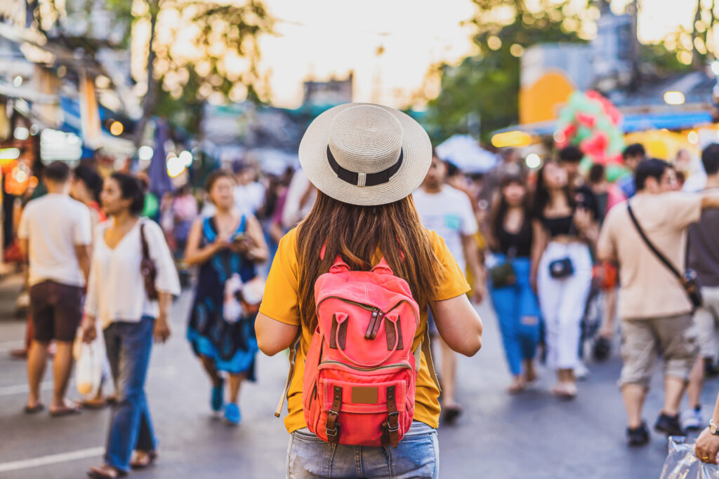Requisitos para visa de turista: Fotografía desde atrás de una mujer de blusa amarilla y sombrero color beige.